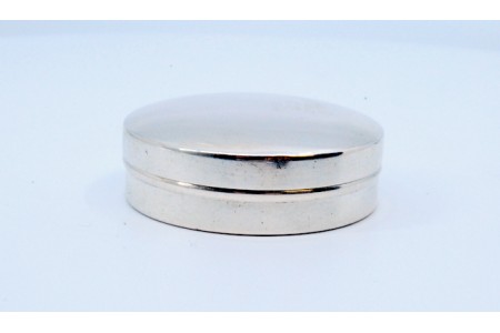 Caixa de comprimidos em prata lisa de forma circular com interior dourado e tampa amovível.